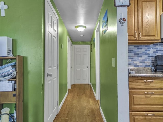hallway with baseboards and wood finished floors