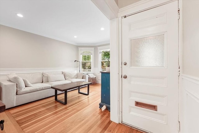 living room featuring light wood-type flooring and crown molding