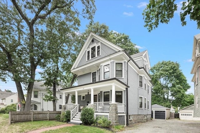 view of front of property featuring covered porch, a garage, and an outdoor structure