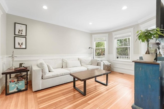 living room with crown molding and hardwood / wood-style floors