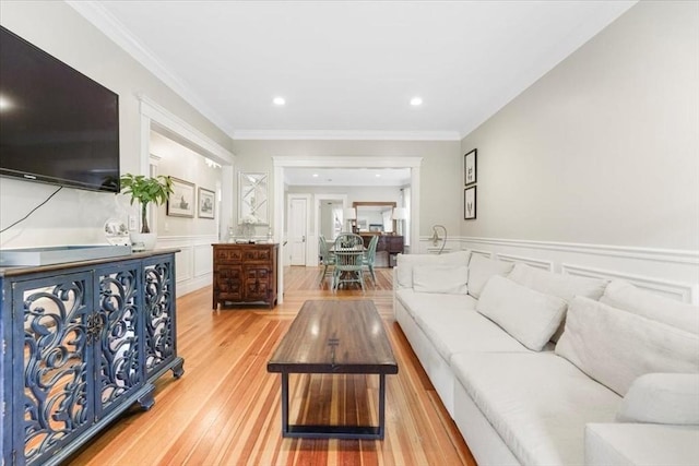 living room featuring light wood-type flooring and ornamental molding