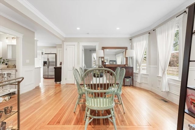 dining room featuring light hardwood / wood-style floors and crown molding