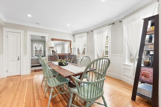 dining area featuring light wood-type flooring and ornamental molding