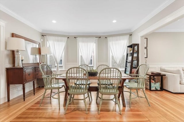 dining space with light wood-type flooring and crown molding