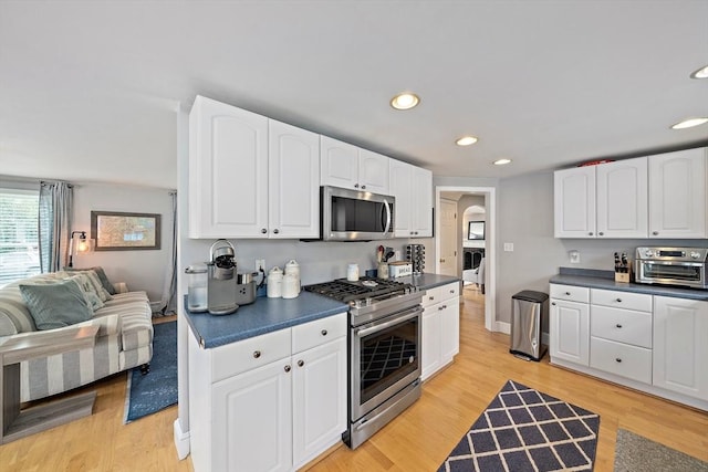 kitchen featuring dark countertops, appliances with stainless steel finishes, a toaster, and recessed lighting