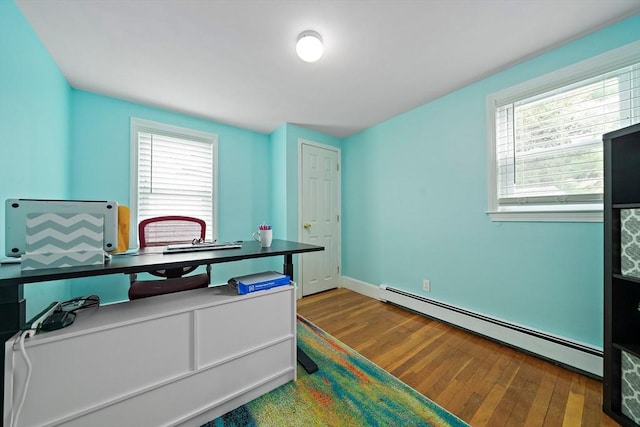 office featuring baseboards, a baseboard heating unit, and wood finished floors