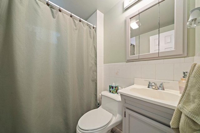 full bathroom with toilet, tile walls, a wainscoted wall, and vanity