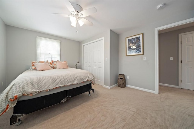bedroom with a closet, a ceiling fan, baseboards, and light colored carpet