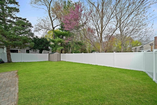 view of yard featuring an outdoor structure, a fenced backyard, and a shed