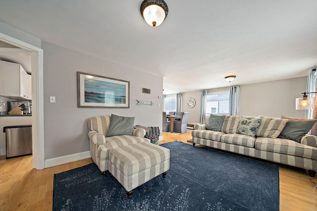 living room with baseboards and light wood finished floors