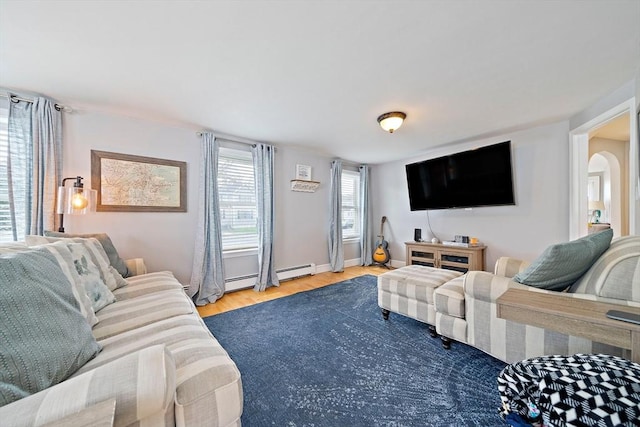 living area featuring arched walkways, a baseboard radiator, baseboards, and wood finished floors
