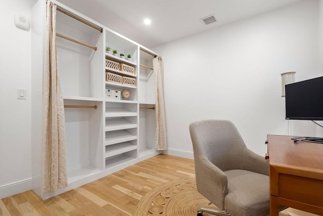 home office with wood-type flooring and built in features