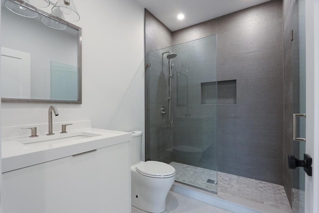 bathroom with vanity, toilet, and a shower with shower door