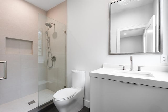 bathroom featuring vanity, toilet, and a shower with door