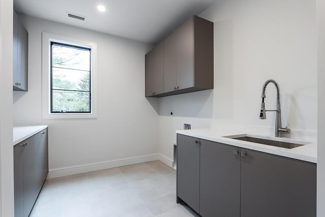 washroom featuring sink, hookup for a washing machine, hookup for an electric dryer, and cabinets