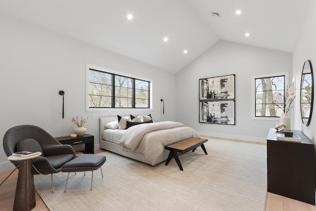 bedroom featuring light hardwood / wood-style floors and high vaulted ceiling