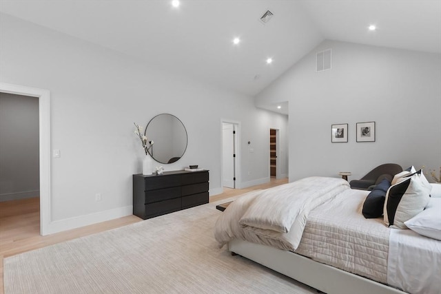 bedroom featuring light wood-type flooring and high vaulted ceiling