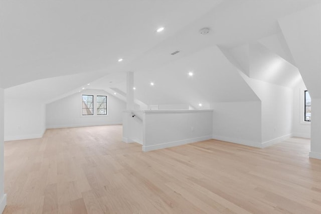 additional living space featuring light hardwood / wood-style floors and vaulted ceiling