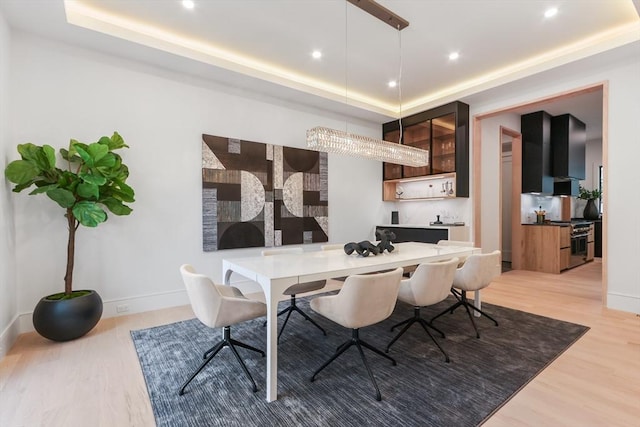 dining area featuring hardwood / wood-style flooring and a raised ceiling