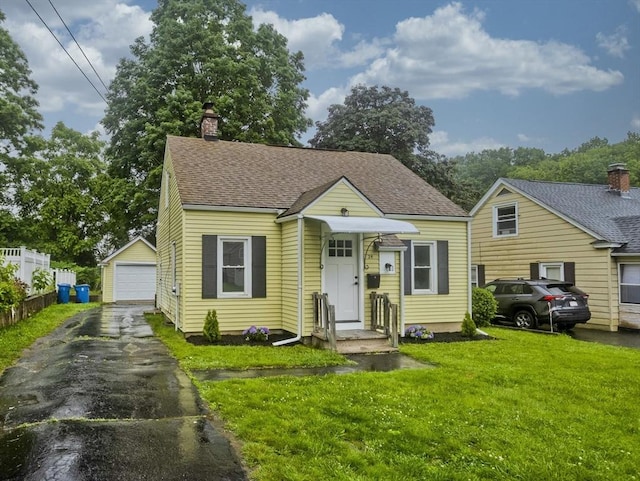 24 City View Ave, West Springfield, MA 01089 - bungalow-style house featuring a detached garage, an outbuilding, a chimney, and a shingled roof
