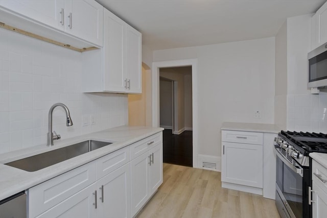 24 City View Ave, West Springfield, MA 01089 - kitchen featuring stainless steel appliances, white cabinetry, decorative backsplash, and light countertops