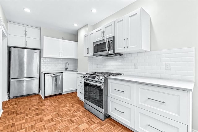 kitchen with white cabinetry, tasteful backsplash, appliances with stainless steel finishes, and light countertops