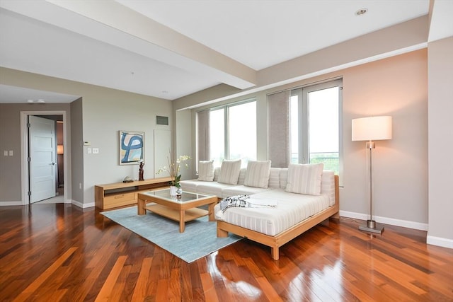 living room featuring beamed ceiling and dark hardwood / wood-style flooring