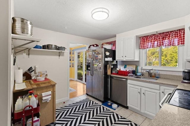 212 Washington St Unit 212, Canton, MA 02021 - kitchen with stainless steel appliances, a sink, a textured ceiling, white cabinets, and light countertops