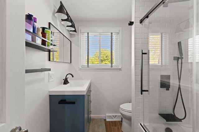 212 Washington St Unit 212, Canton, MA 02021 - full bath featuring vanity, a shower stall, toilet, wood finished floors, and baseboards