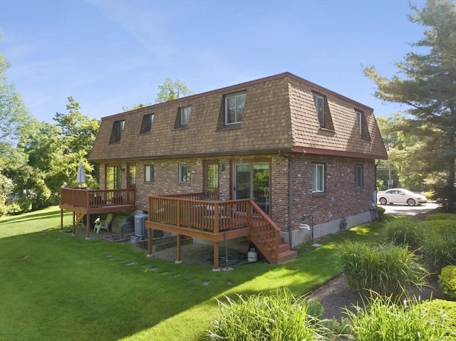 212 Washington St Unit 212, Canton, MA 02021 - back of property with brick siding, a deck, a lawn, mansard roof, and central air condition unit