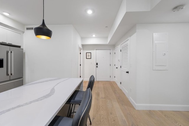 101 Condor St Unit 301A, Boston, MA 02128 - kitchen with high end refrigerator, electric panel, light wood-style floors, white cabinetry, and decorative light fixtures