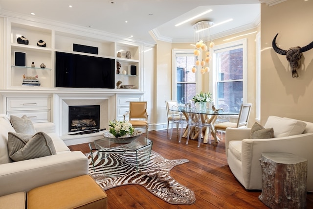 living room featuring an inviting chandelier, dark hardwood / wood-style floors, and ornamental molding