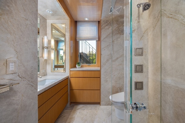 bathroom with walk in shower, vanity, tile walls, and toilet