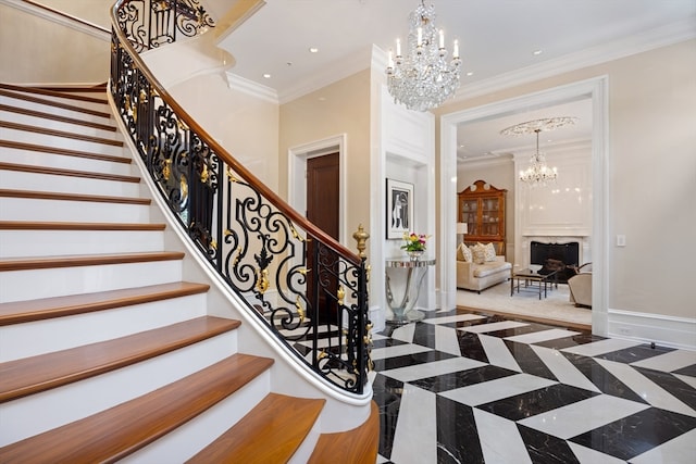 foyer with a notable chandelier, crown molding, and a premium fireplace