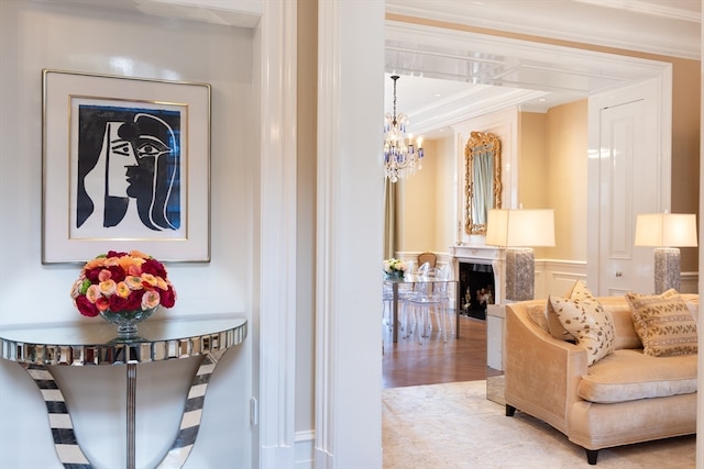 interior space featuring ornamental molding, an inviting chandelier, light hardwood / wood-style flooring, and a premium fireplace