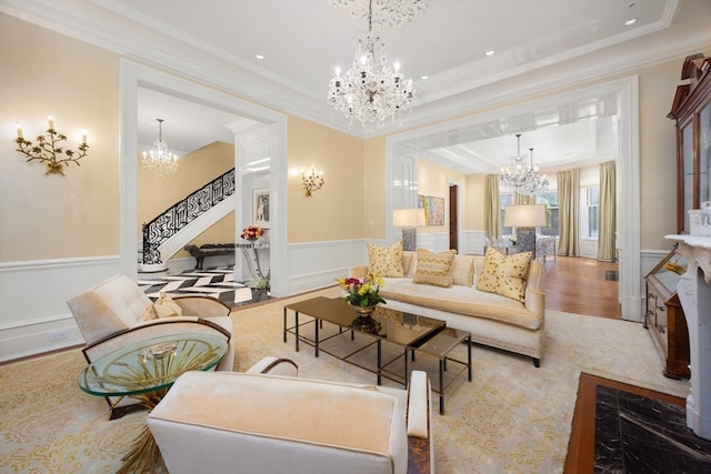 living room with crown molding, light hardwood / wood-style floors, and a notable chandelier