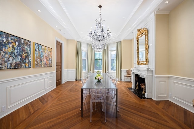 dining space featuring ornamental molding, a high end fireplace, a notable chandelier, and parquet flooring