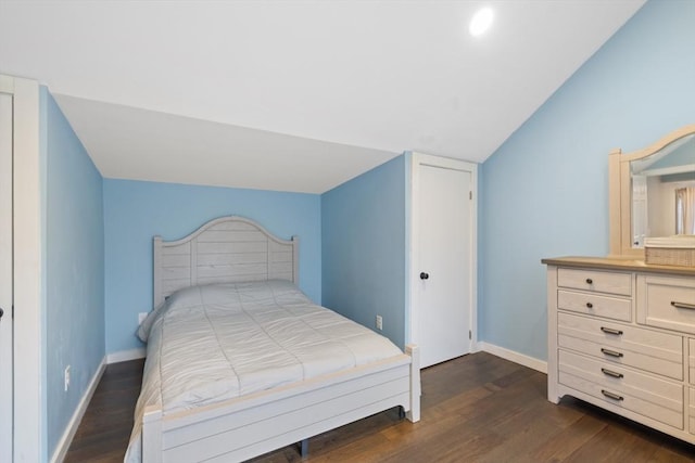 bedroom featuring baseboards, dark wood-type flooring, and vaulted ceiling