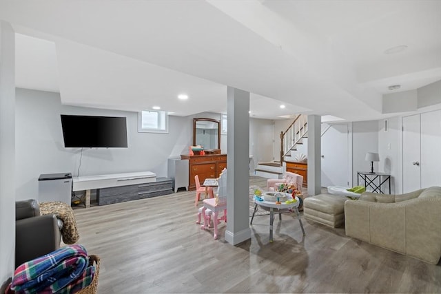 living area with recessed lighting, wood finished floors, and stairs