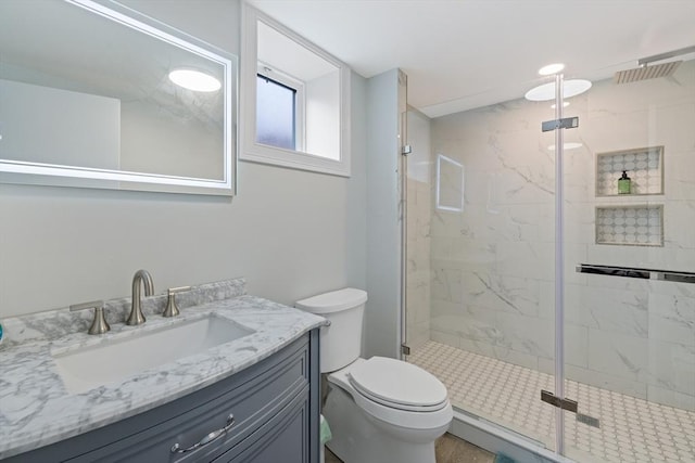 full bath with a marble finish shower, toilet, and vanity