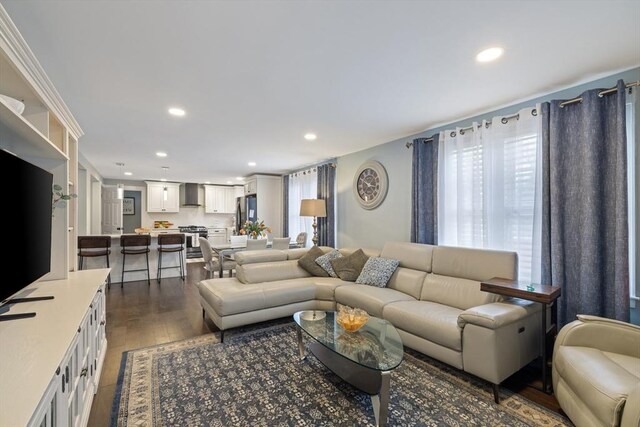 living room with recessed lighting and dark wood-style floors