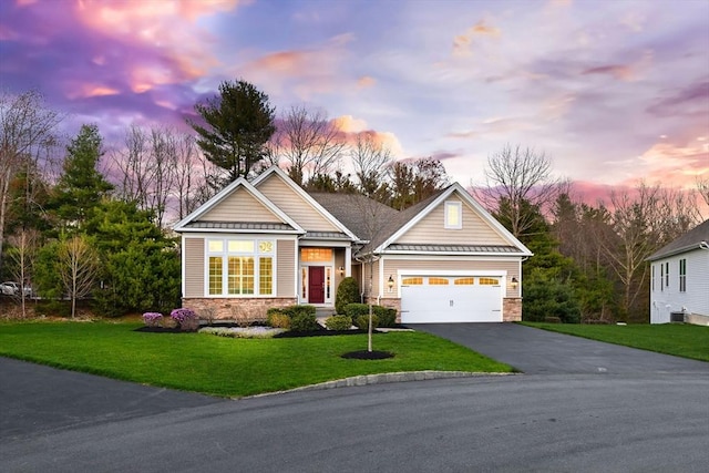 craftsman inspired home with aphalt driveway, a garage, stone siding, a standing seam roof, and a lawn