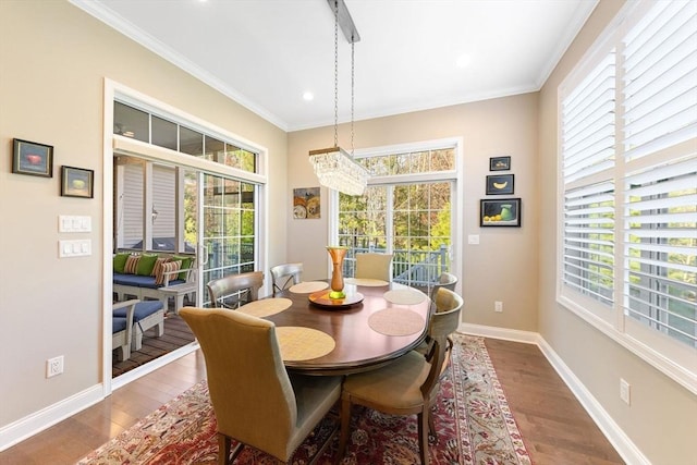 dining space with baseboards, an inviting chandelier, a wealth of natural light, and wood finished floors