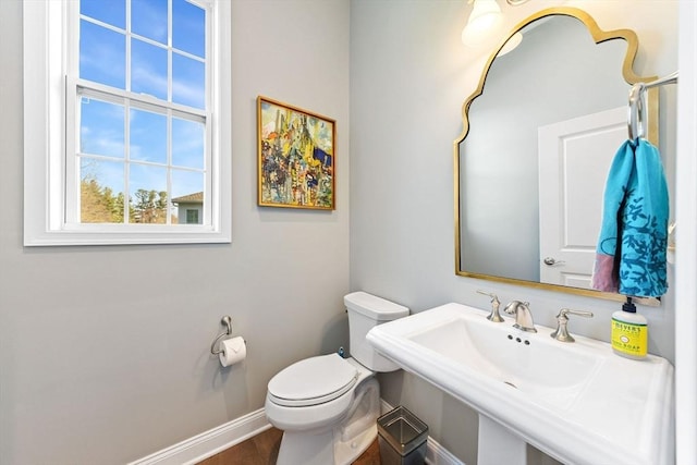 bathroom featuring baseboards, a sink, and toilet