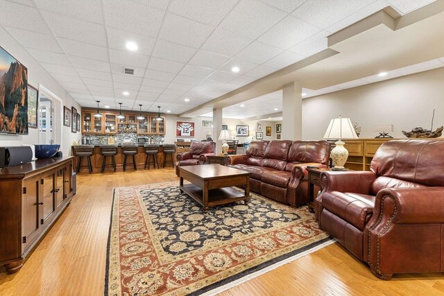 living area featuring light wood-style floors and bar area