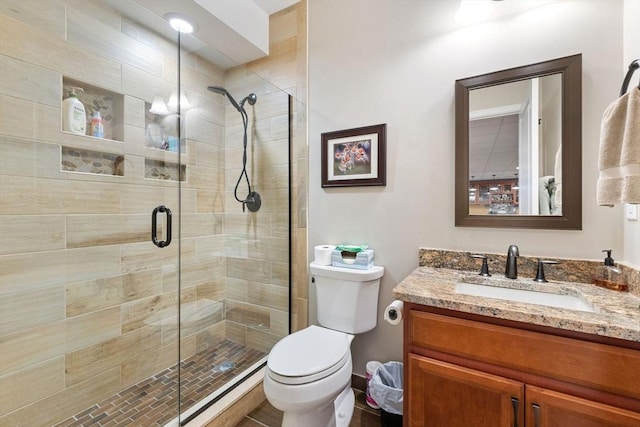 full bath with toilet, a shower stall, baseboard heating, and vanity