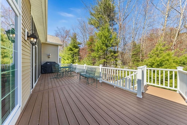 wooden terrace with area for grilling and outdoor dining space