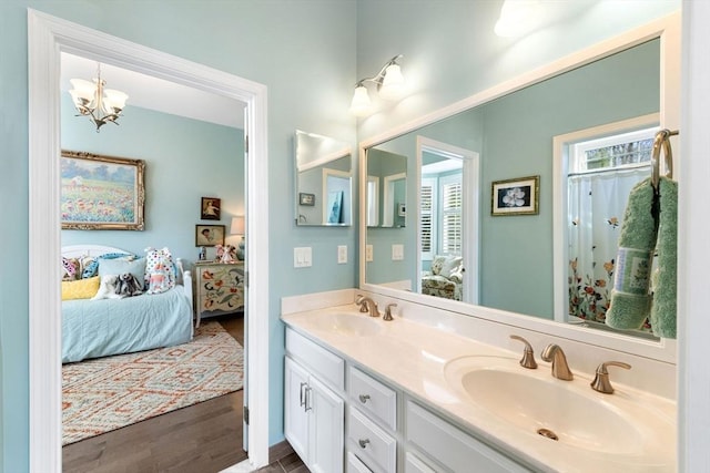 bathroom featuring connected bathroom, double vanity, a sink, and wood finished floors