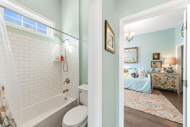 ensuite bathroom with connected bathroom, wood finished floors, shower / tub combo, toilet, and a chandelier