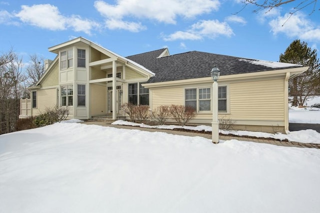 view of snow covered rear of property